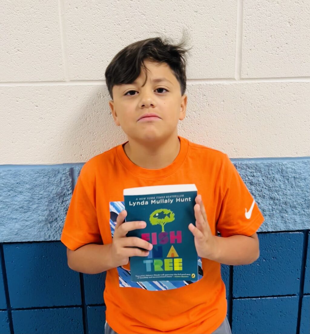 image_student receiving a book for earning a Aviator or Rise praise award