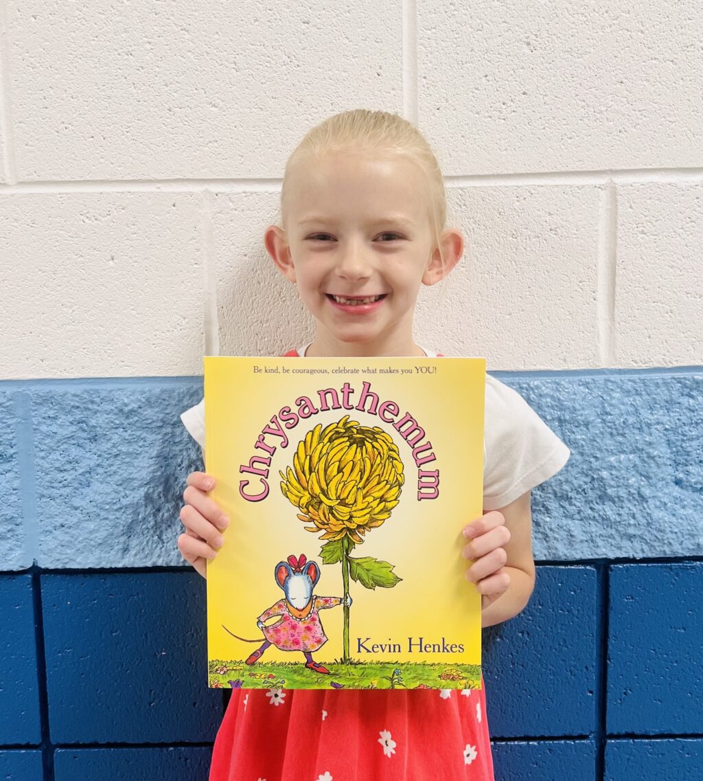 image_student receiving a book for earning a Aviator or Rise praise award