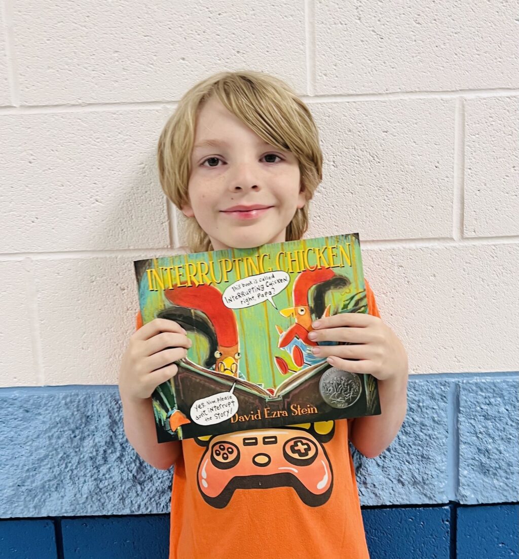 image_student receiving a book for earning a Aviator or Rise praise award