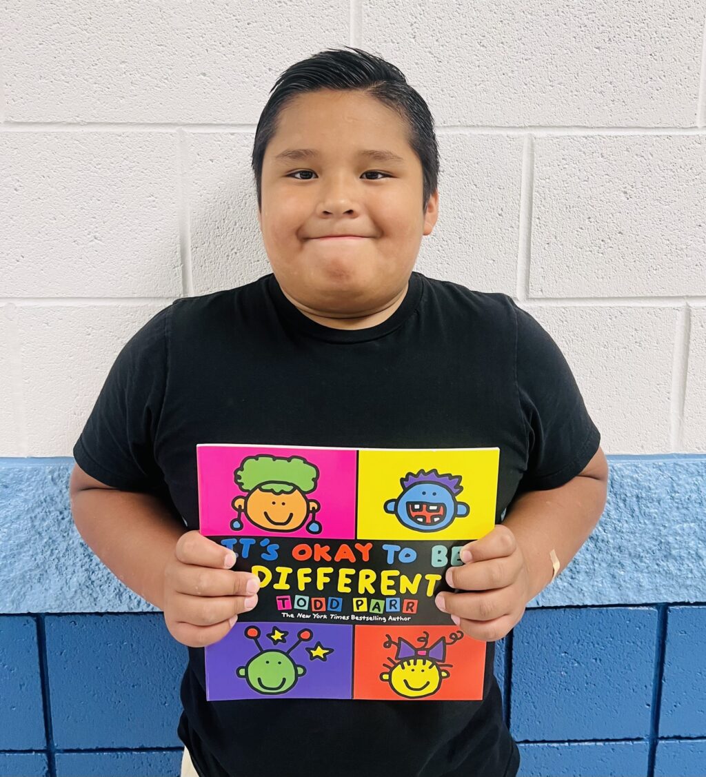 image_student receiving a book for earning a Aviator or Rise praise award