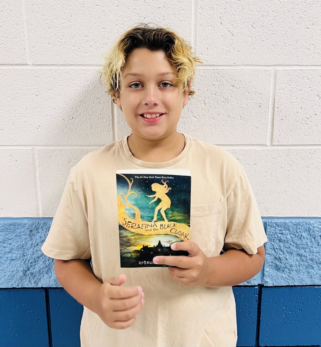 image_student receiving a book for earning a Aviator or Rise praise award