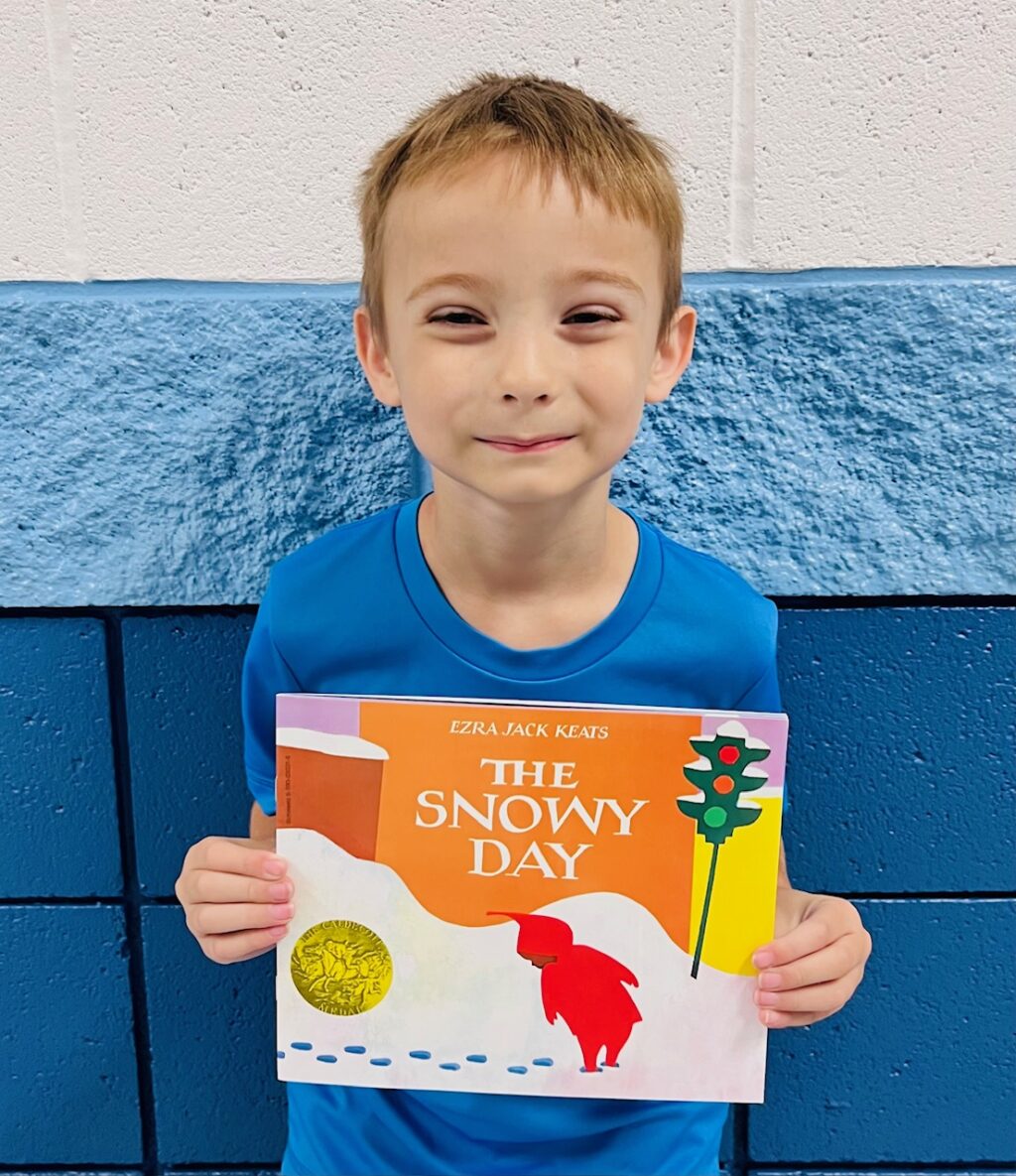 image_student receiving a book for earning a Aviator or Rise praise award