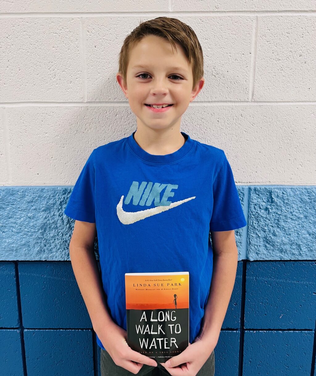 image_student receiving a book for earning a Aviator or Rise praise award