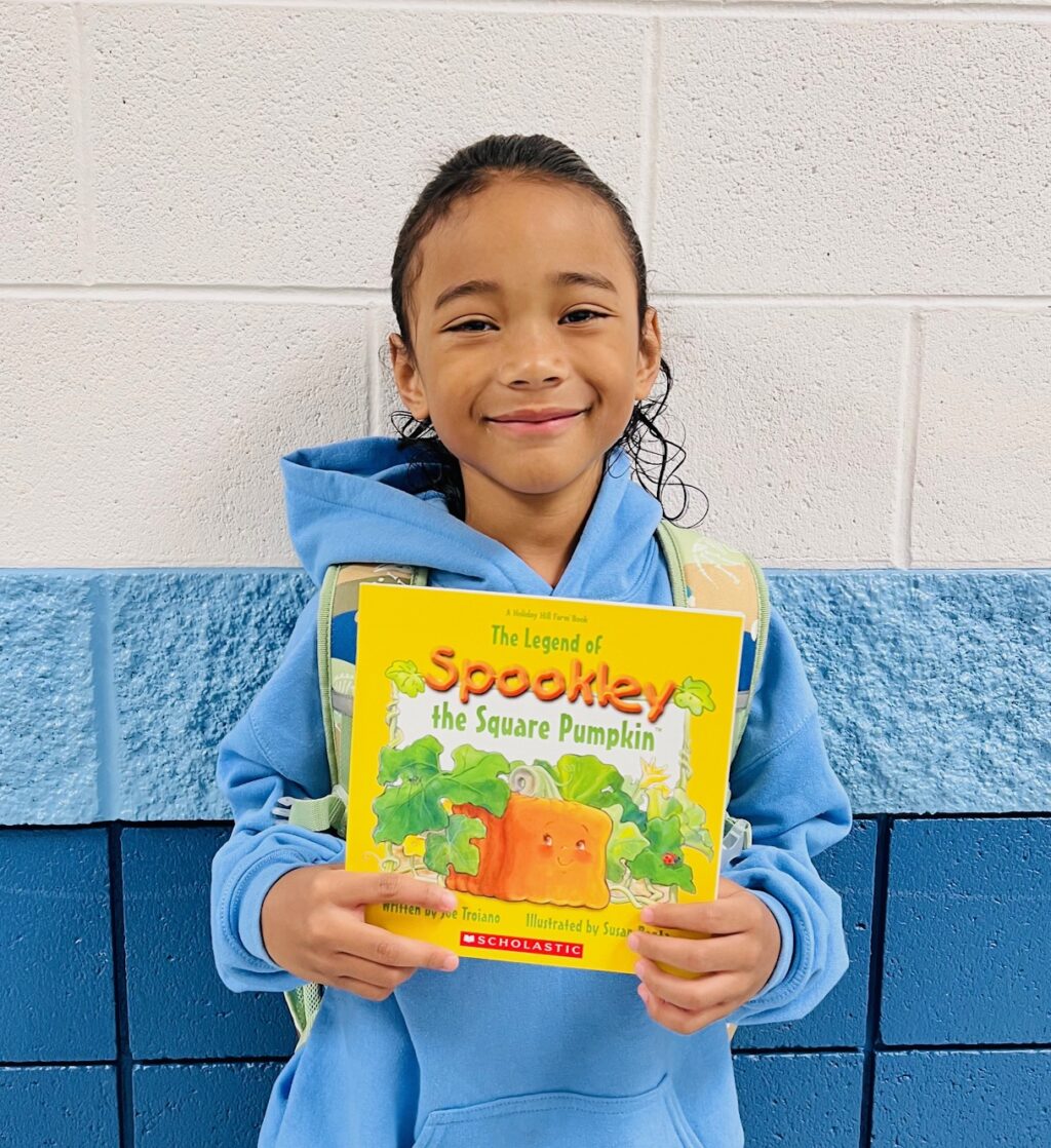 image_student receiving a book for earning a Aviator or Rise praise award