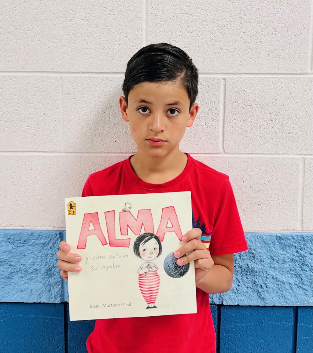 image_student receiving a book for earning a Aviator or Rise praise award