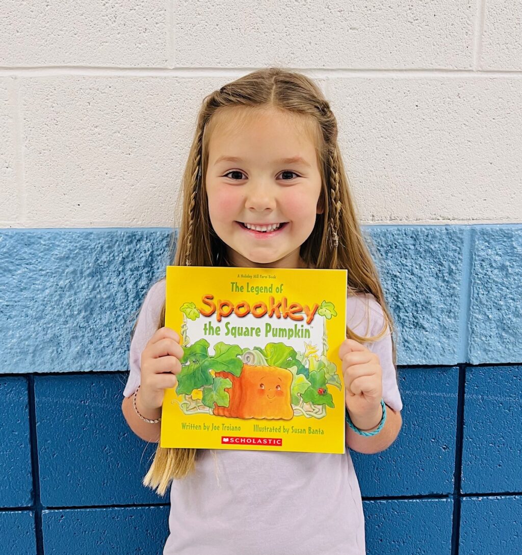 image_student receiving a book for earning a Aviator or Rise praise award