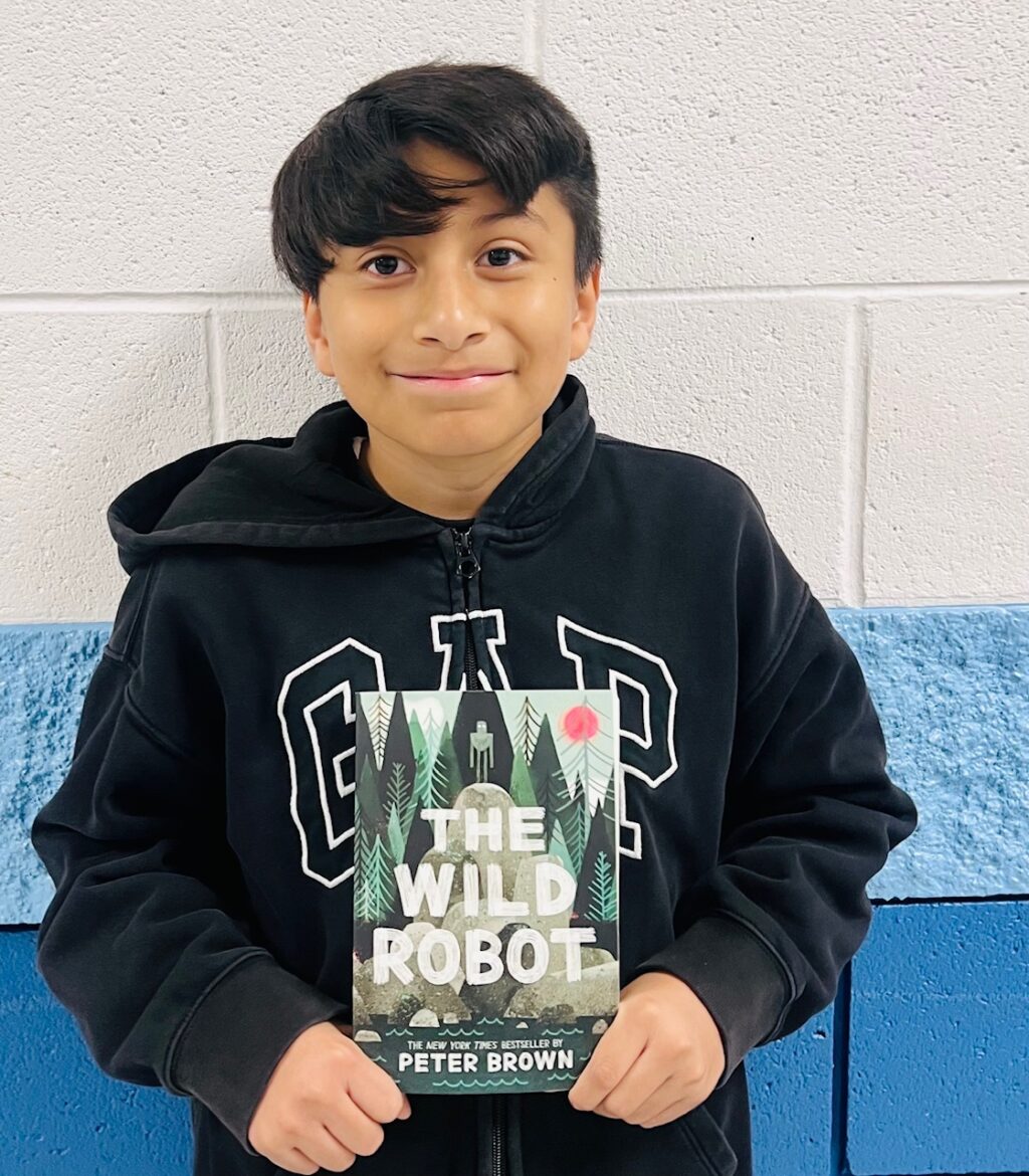 image_student receiving a book for earning a Aviator or Rise praise award