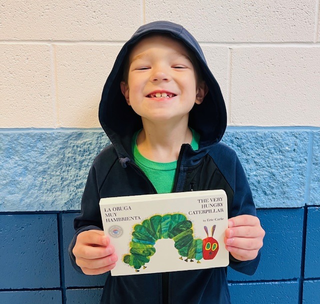 student holding a book earned as an award