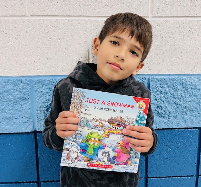 student receives praise award holding a book