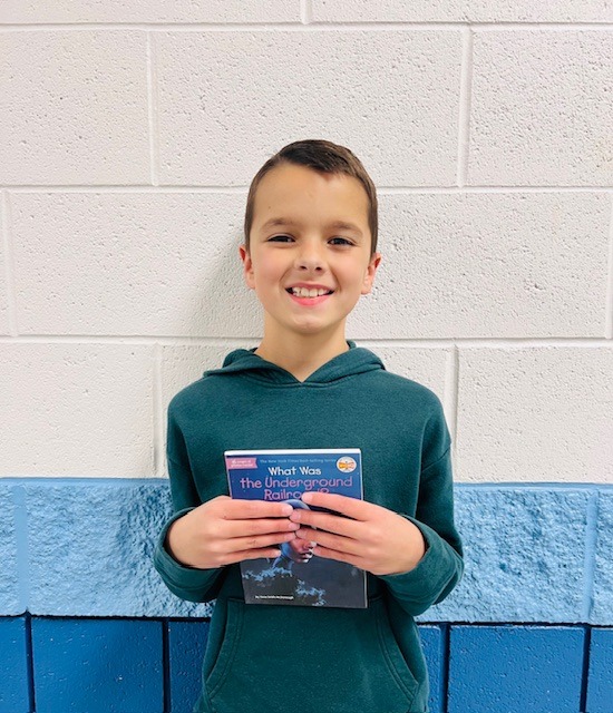 student receives praise award holding a book