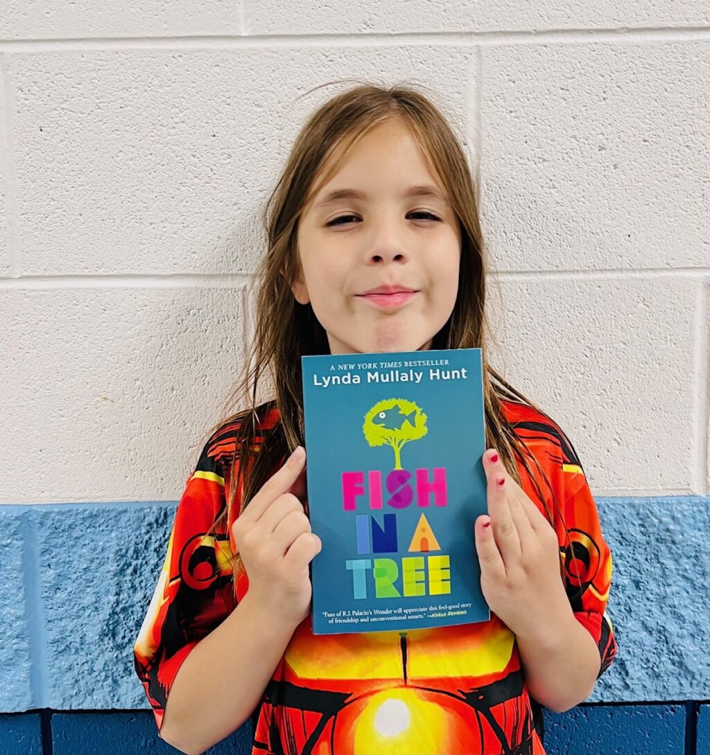 Image_student holding a book for earning an aviator or rise praise award