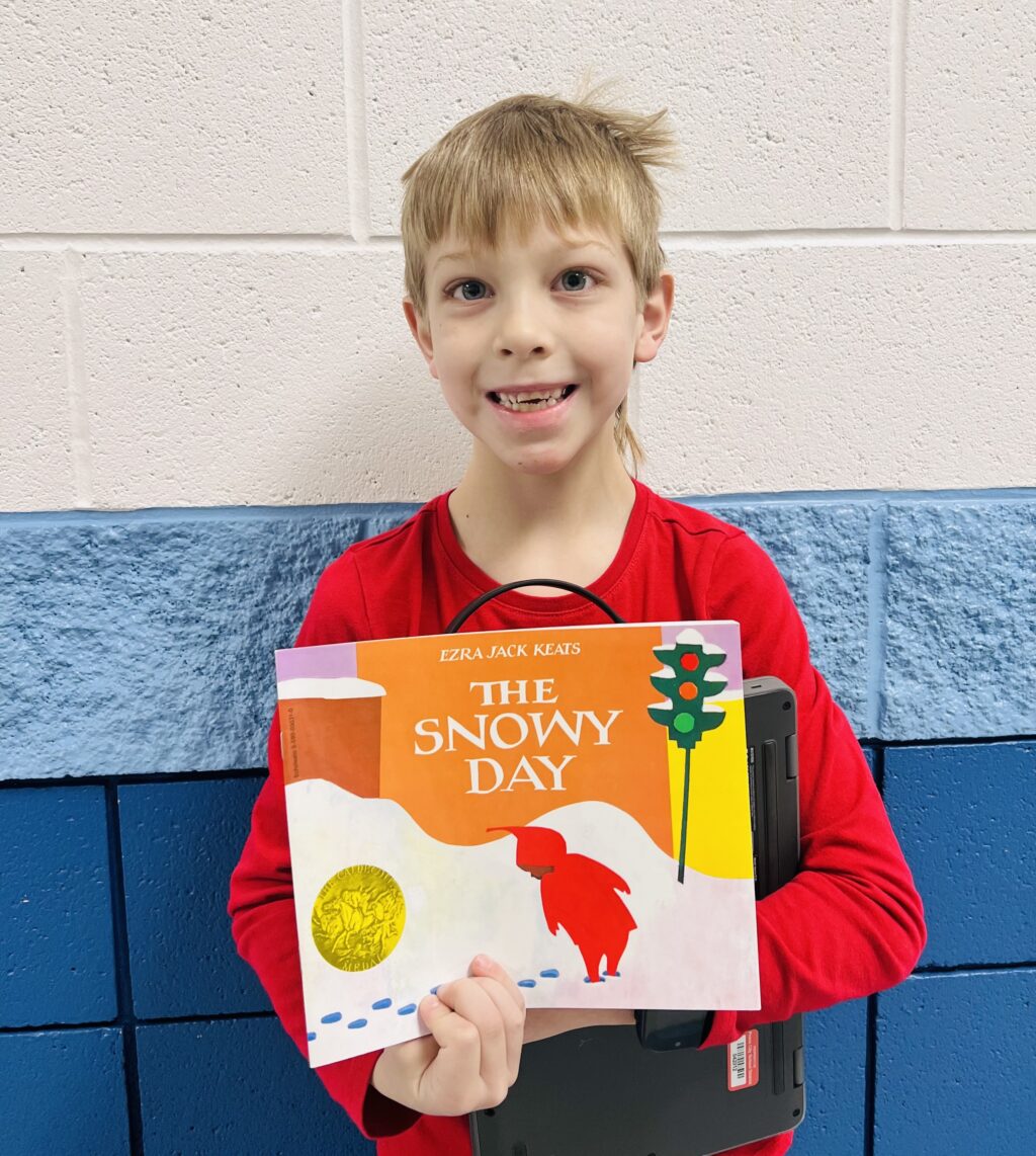 student holding a book they earned through a special recognition