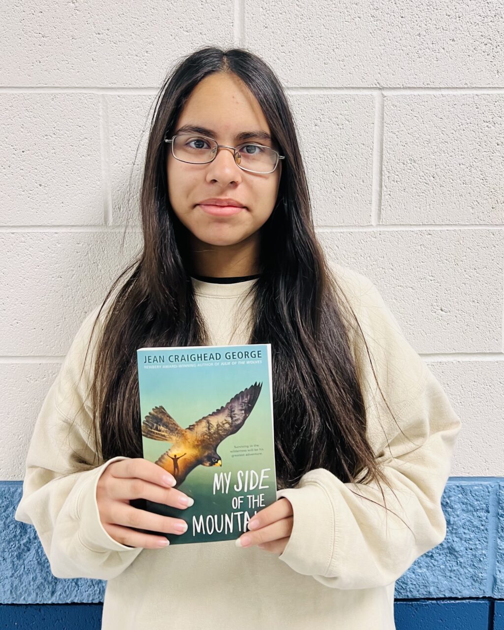 student holding a book they earned through a special recognition