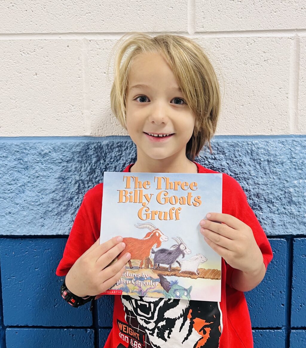 student holding a book they earned through a special recognition