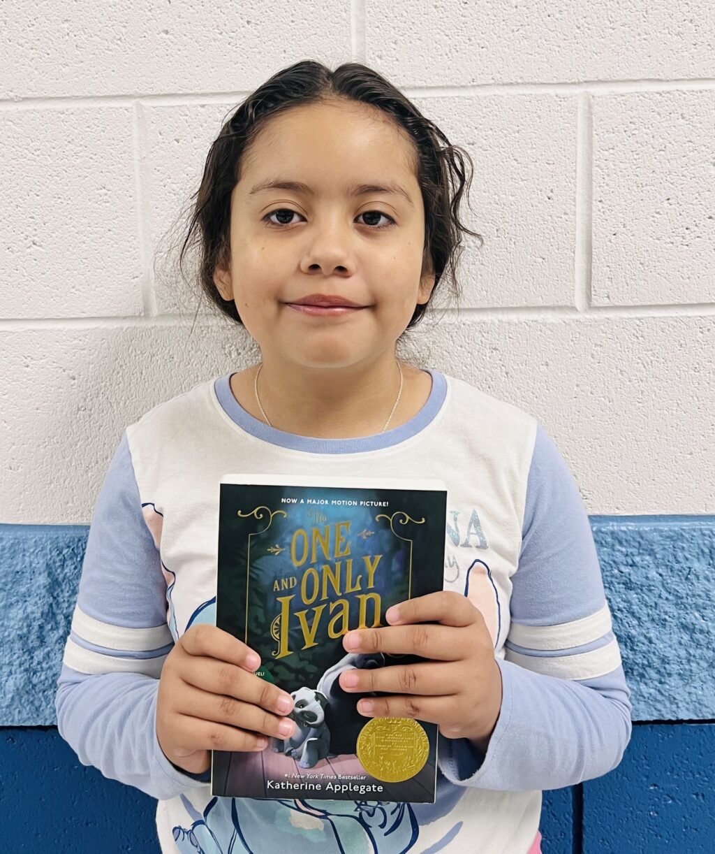 student holding a book they earned through a special recognition