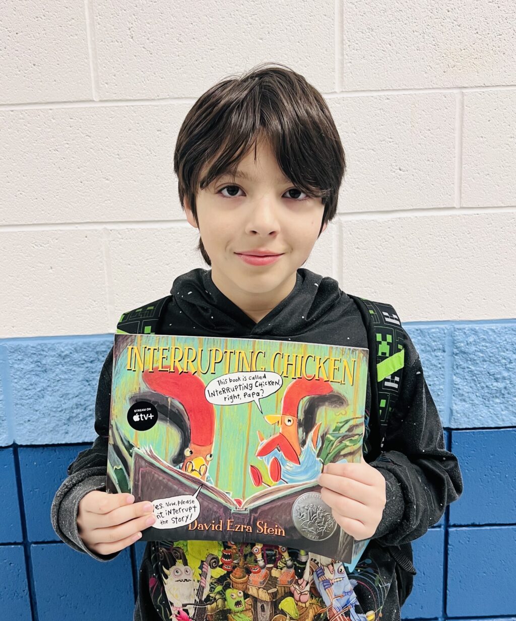 student holding a book they earned through a special recognition