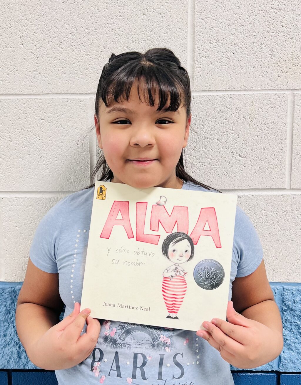 student holding a book they earned through a special recognition