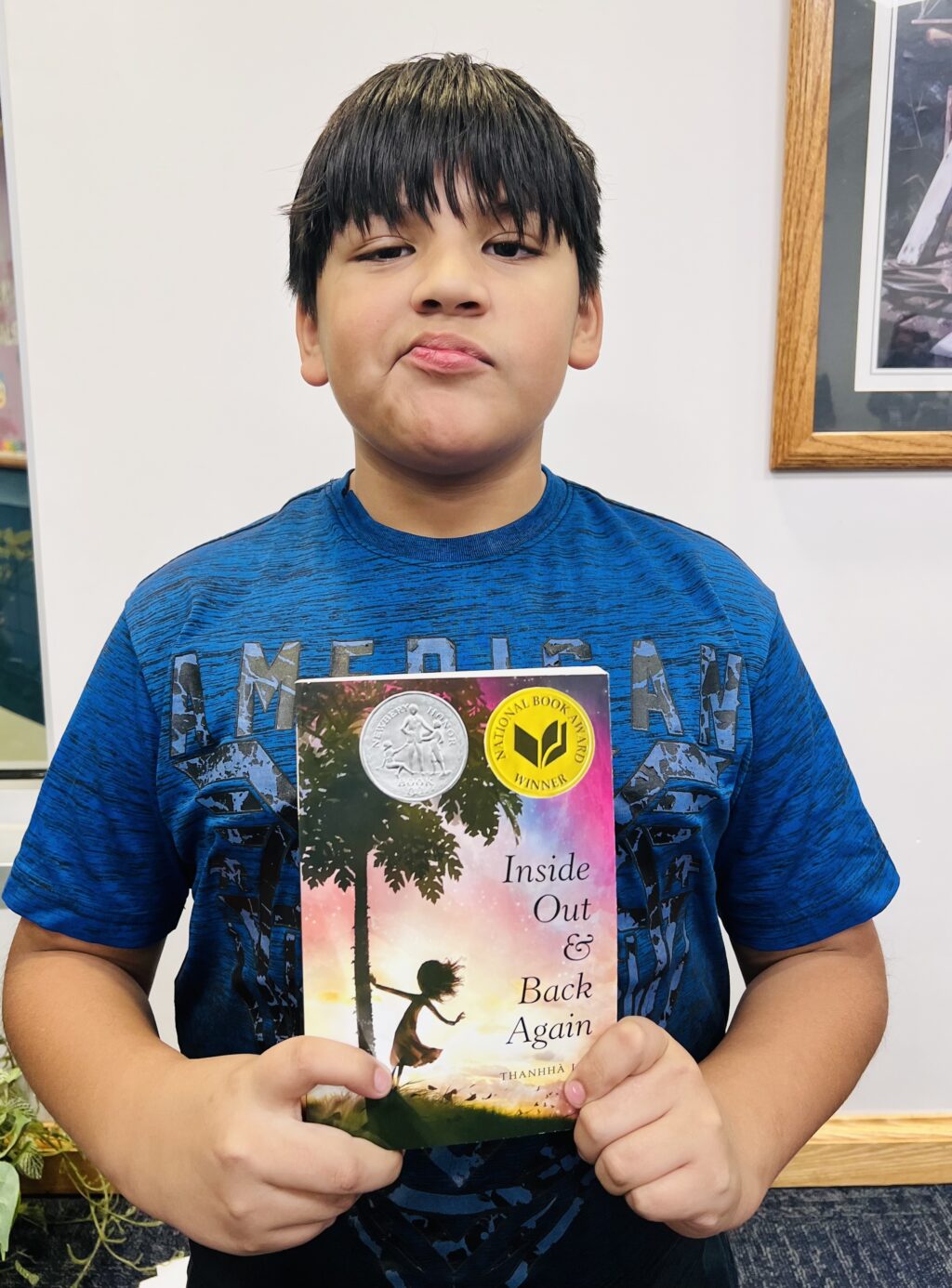 student holding a book they earned through a special recognition