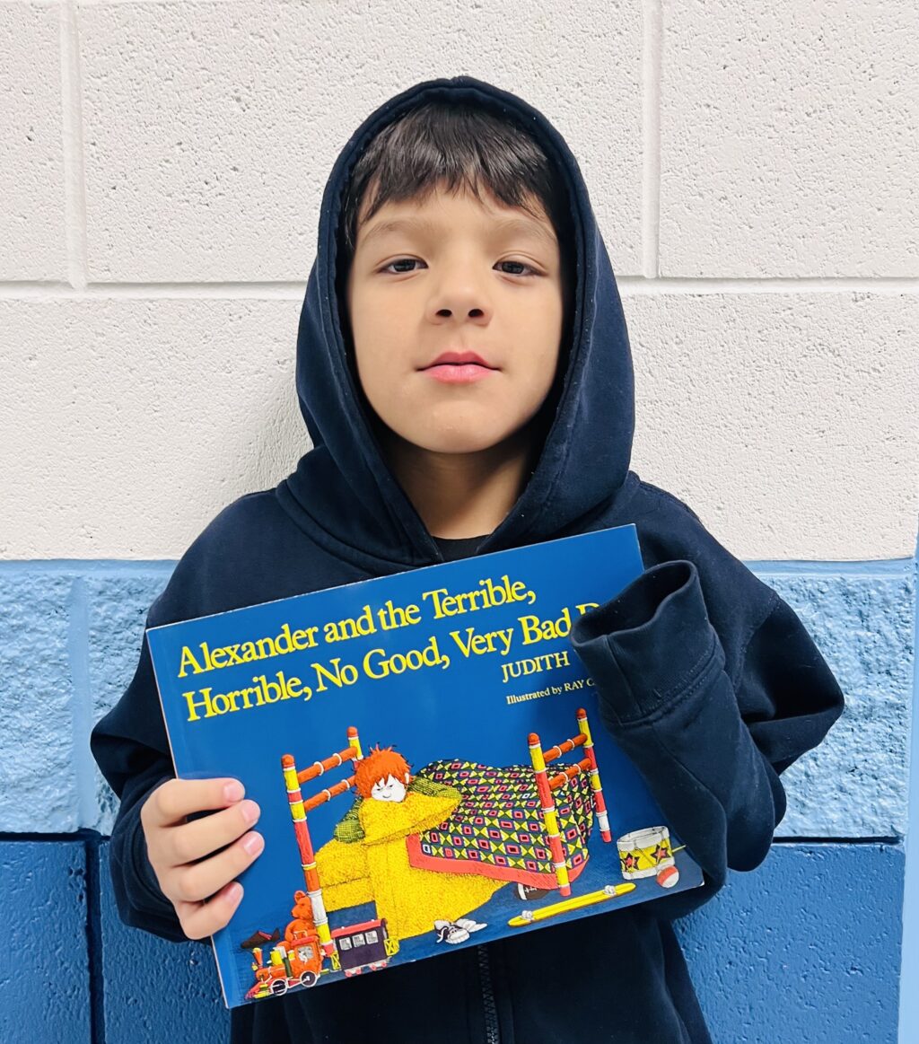 student holding a book they earned through a special recognition