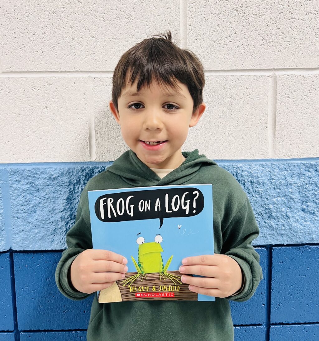 student holding a book they earned through a special recognition