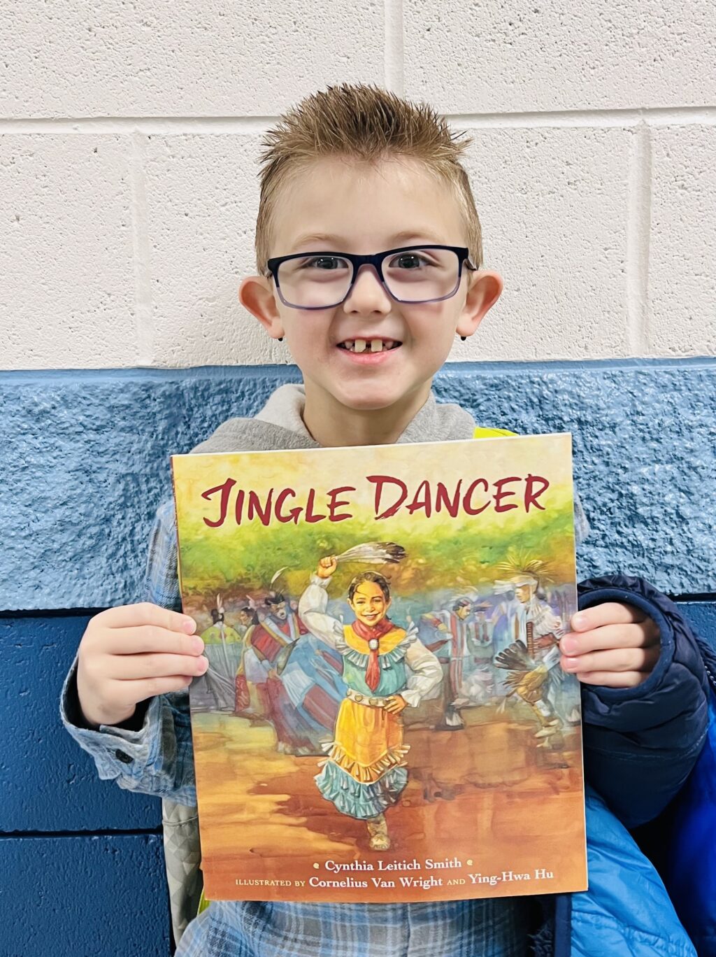 student holding a book they earned through a special recognition