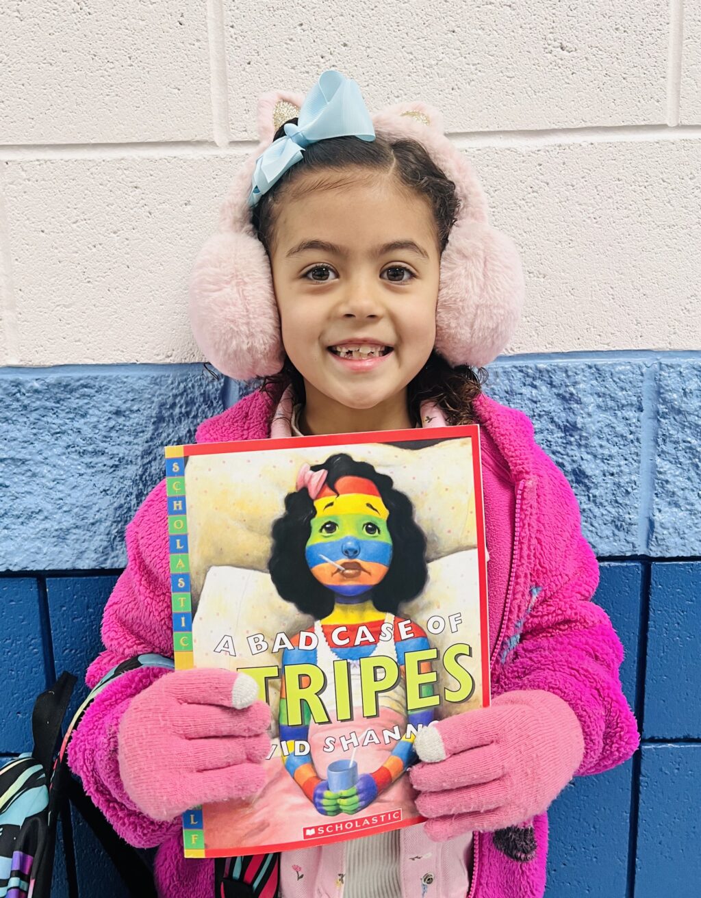 student holding a book they earned through a special recognition