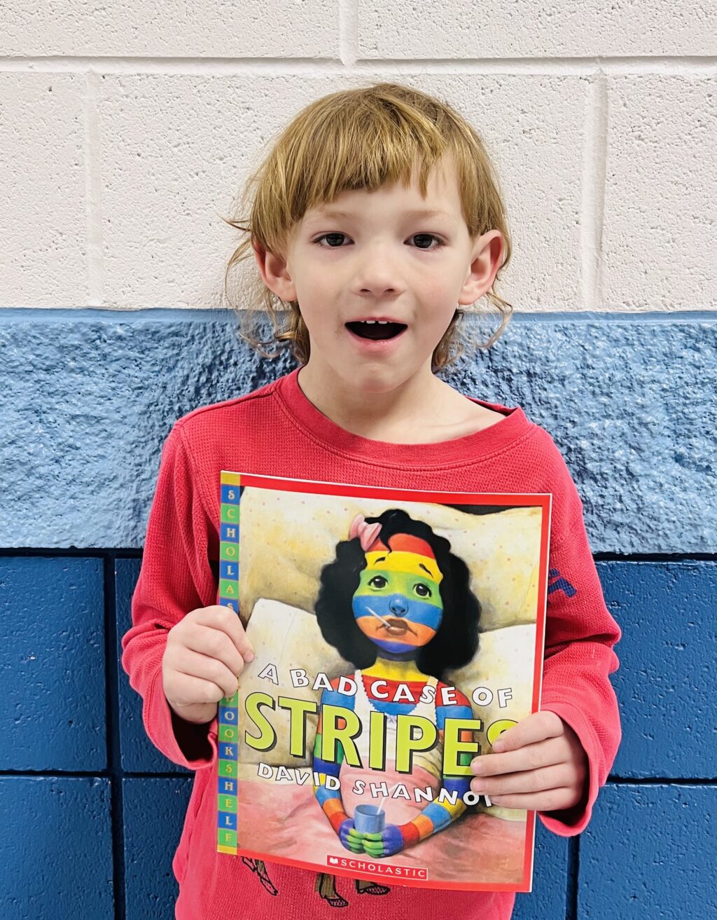 student holding a book they earned through a special recognition