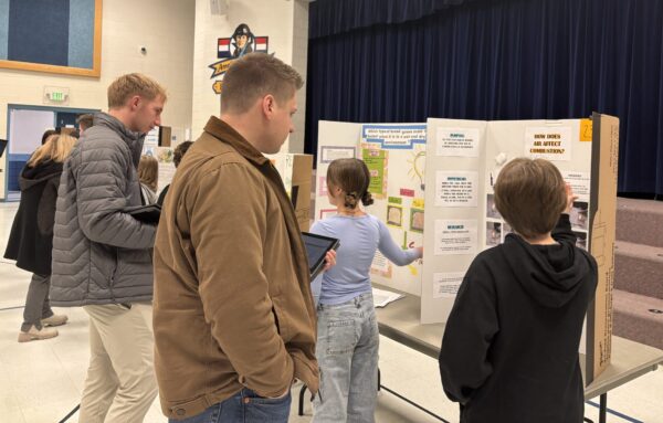 Amelia Earhart students are talking with STEM fair judges about their projects.