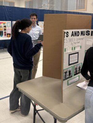 Amelia Earhart students are talking with STEM fair judges about their projects.