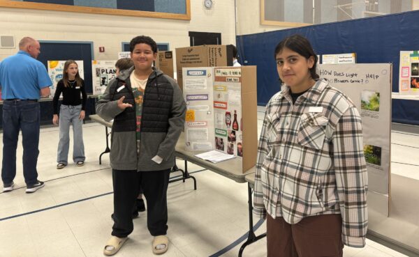 Amelia Earhart students are talking with STEM fair judges about their projects.