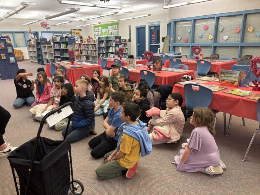 Students in the library being introduced to book speed dating.