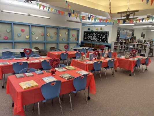 Extra special red table cloths hold the library books for speed dating