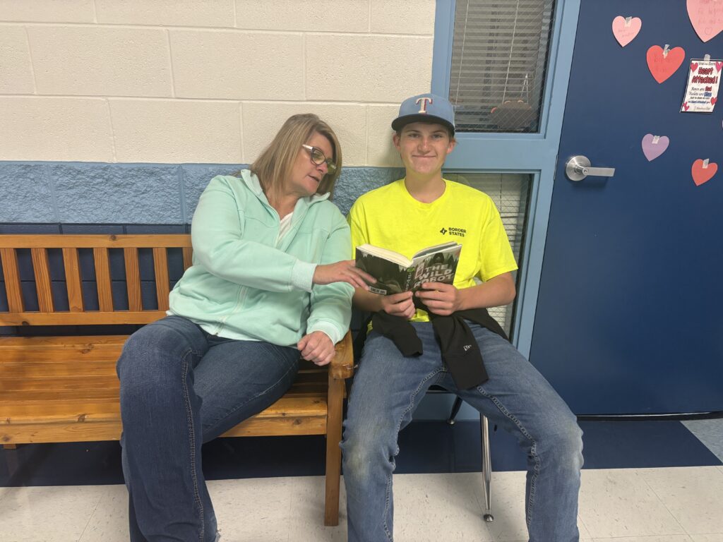 Students reading with  guests that could be parents, grandparents, family friends, or faculty and staff for read with a child day in May