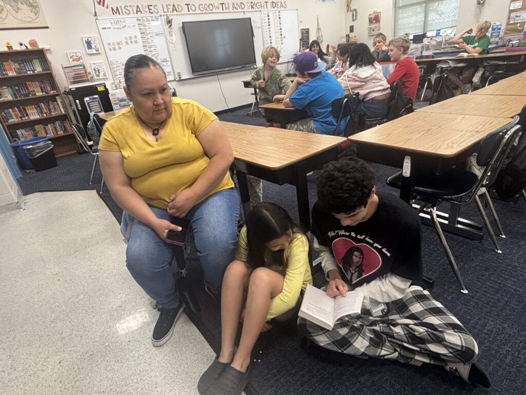 Students reading with  guests that could be parents, grandparents, family friends, or faculty and staff for read with a child day in May