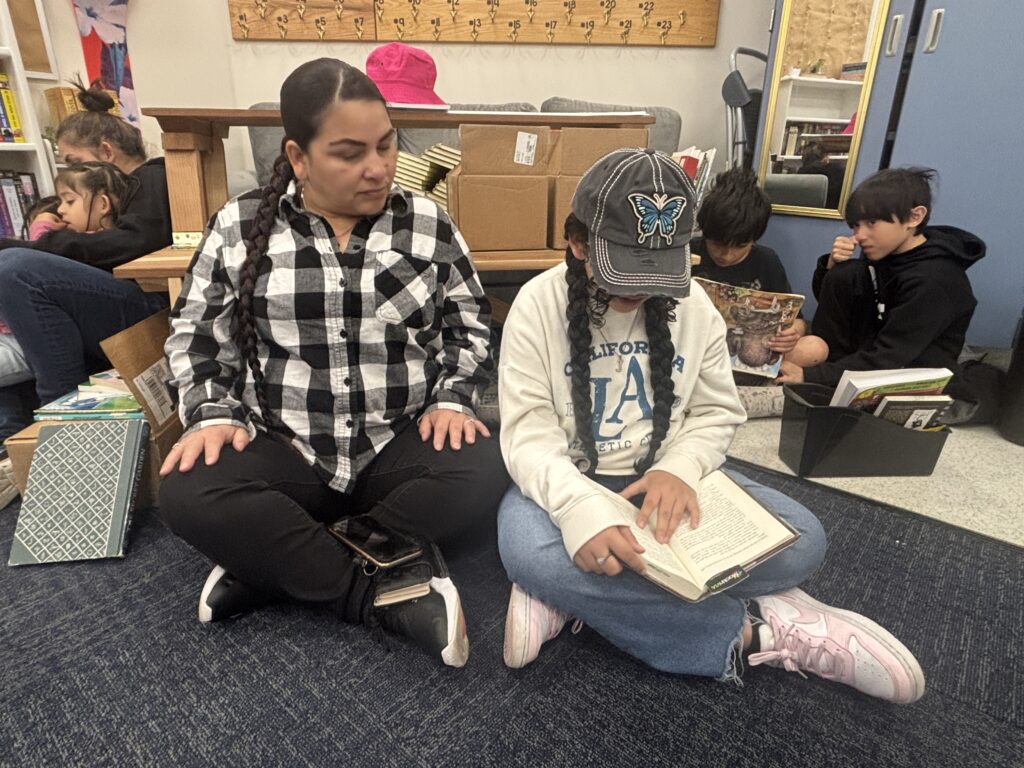 Students reading with  guests that could be parents, grandparents, family friends, or faculty and staff for read with a child day in May