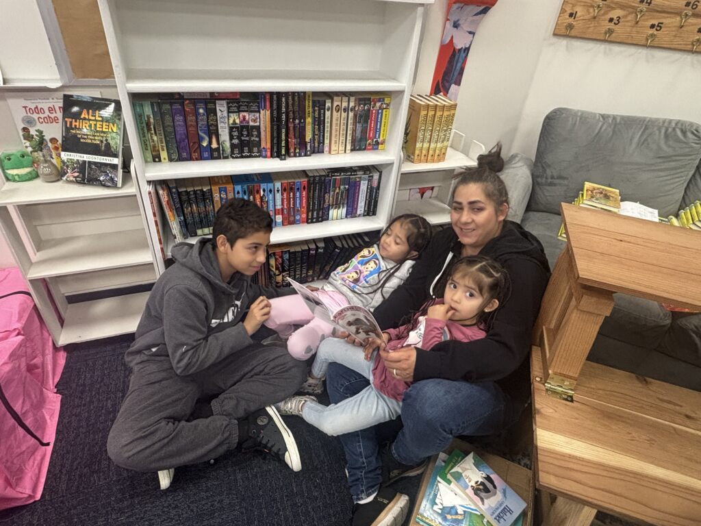 Students reading with  guests that could be parents, grandparents, family friends, or faculty and staff for read with a child day in May