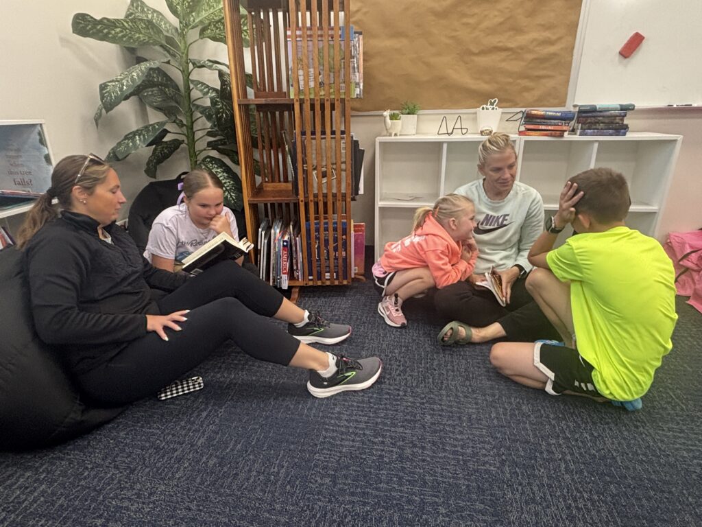 Students reading with  guests that could be parents, grandparents, family friends, or faculty and staff for read with a child day in May