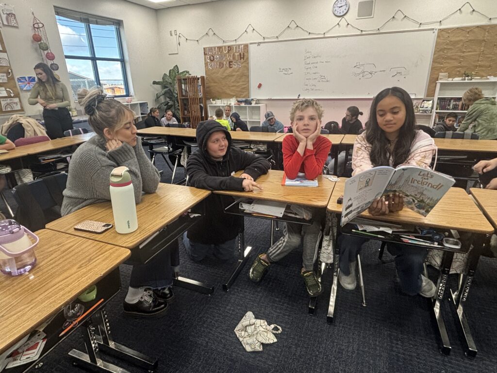 Students reading with  guests that could be parents, grandparents, family friends, or faculty and staff for read with a child day in May