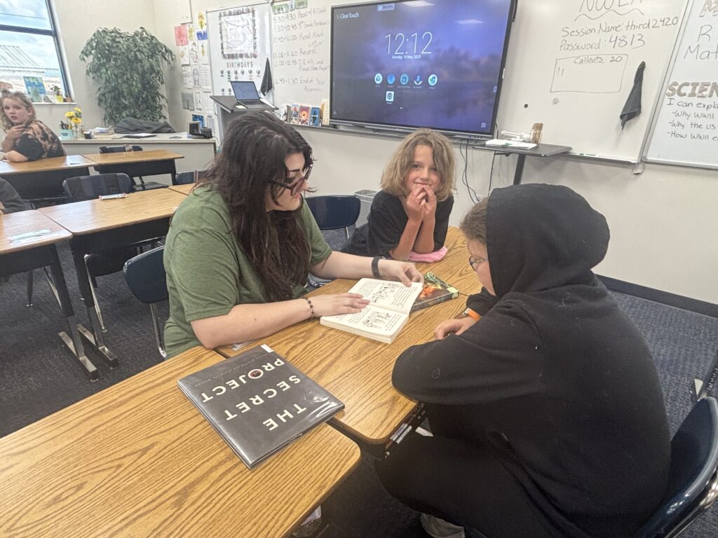 Students reading with  guests that could be parents, grandparents, family friends, or faculty and staff for read with a child day in May