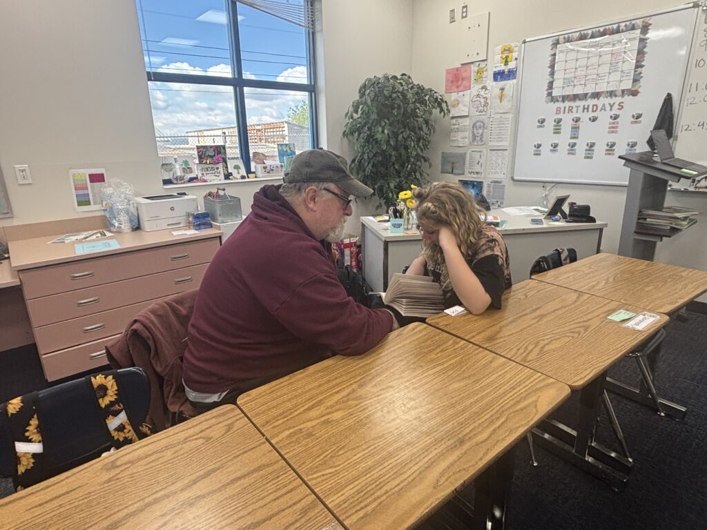Students reading with  guests that could be parents, grandparents, family friends, or faculty and staff for read with a child day in May