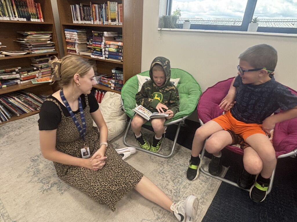 Students reading with  guests that could be parents, grandparents, family friends, or faculty and staff for read with a child day in May