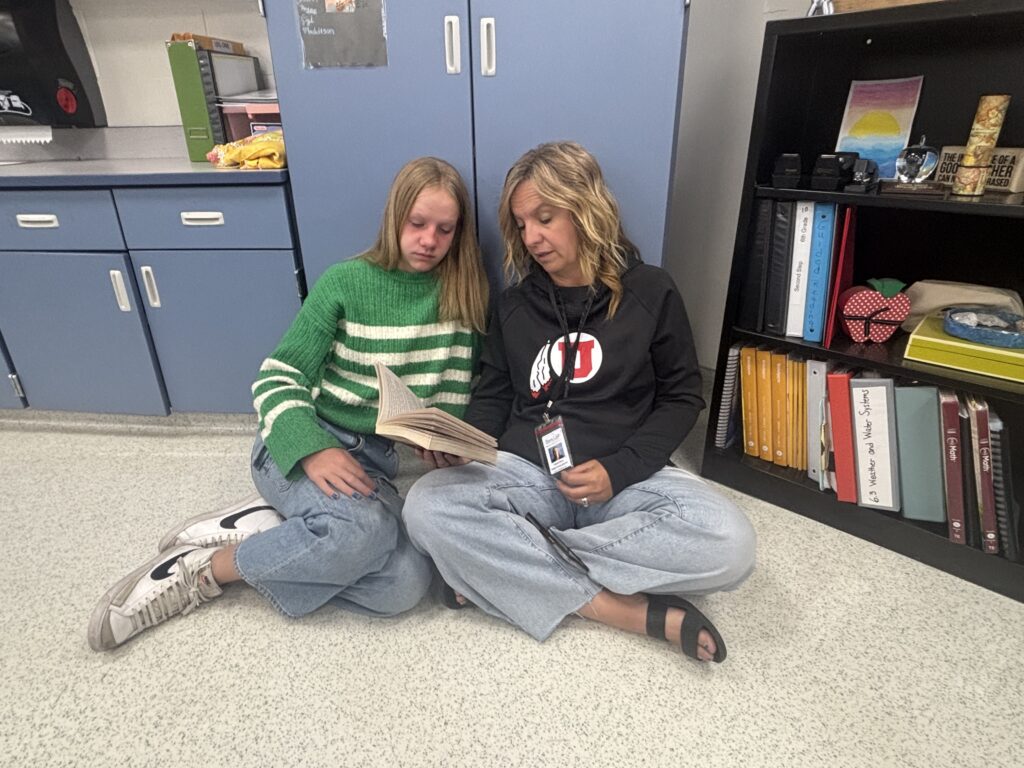 Students reading with  guests that could be parents, grandparents, family friends, or faculty and staff for read with a child day in May