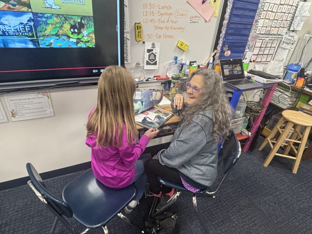 Students reading with  guests that could be parents, grandparents, family friends, or faculty and staff for read with a child day in May