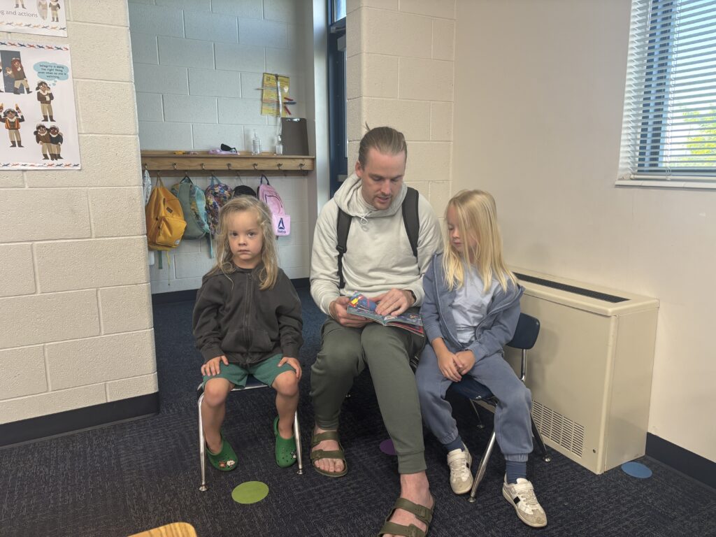 Students reading with  guests that could be parents, grandparents, family friends, or faculty and staff for read with a child day in May