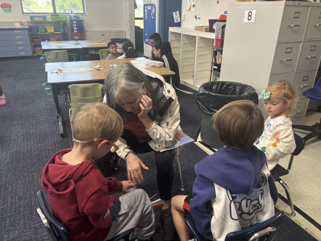 Students reading with  guests that could be parents, grandparents, family friends, or faculty and staff for read with a child day in May