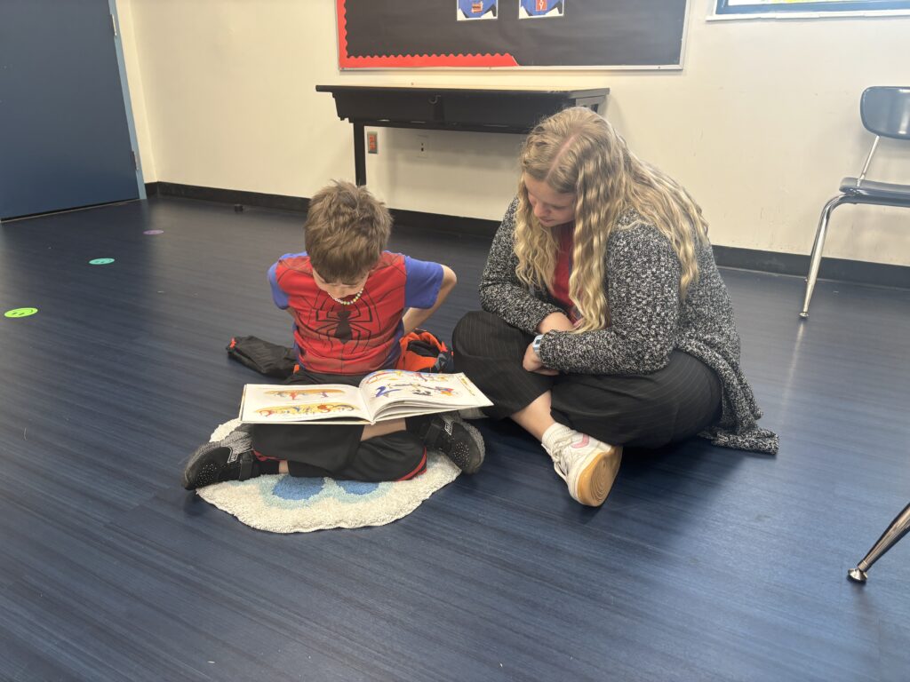 Students reading with  guests that could be parents, grandparents, family friends, or faculty and staff for read with a child day in May