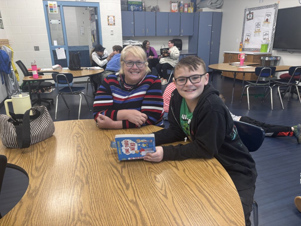 Students reading with  guests that could be parents, grandparents, family friends, or faculty and staff for read with a child day in May