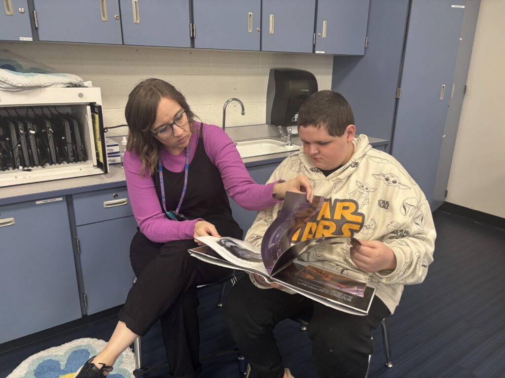 Students reading with  guests that could be parents, grandparents, family friends, or faculty and staff for read with a child day in May