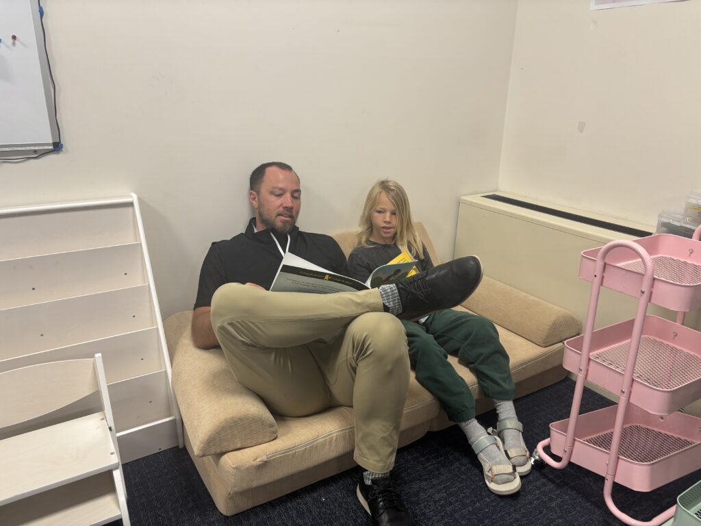 Students reading with  guests that could be parents, grandparents, family friends, or faculty and staff for read with a child day in May