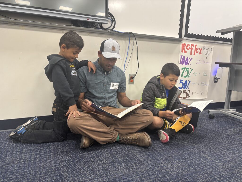 Students reading with  guests that could be parents, grandparents, family friends, or faculty and staff for read with a child day in May
